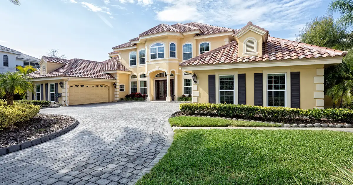 A yellow, Florida style house with multiple windows that are likely covered in 3M house tinting to block UV rays, lower heat and reduce glare.