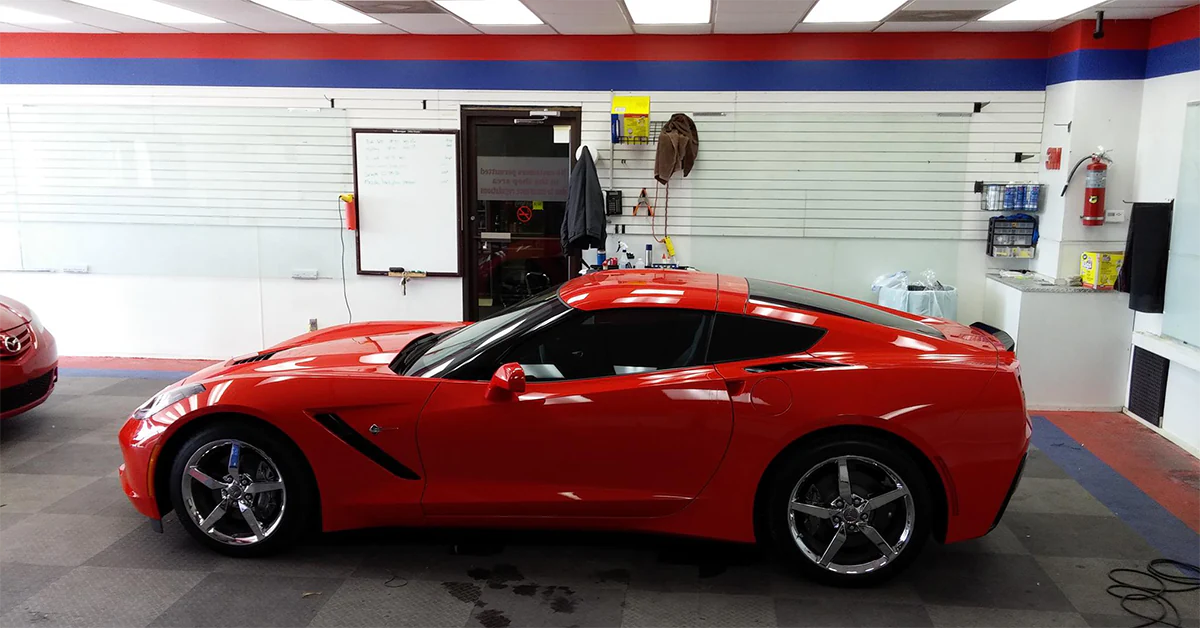 Advanced Window Tinting installed 3M auto tint on a red sports car within its Jacksonville tint shop.