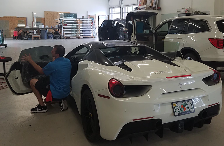 One of Advanced Window Tinting’s professional 3M Window Film installers adds auto tinto to a vehicle parked in the company’s Jacksonville shop.