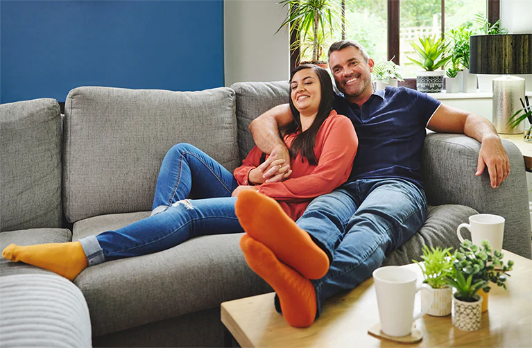 A couple relax on their couch with peace of mind knowing their home is protected with window tinting.