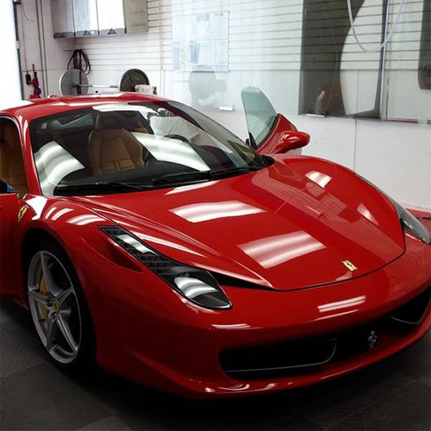 Advanced Window Tinting installed Crystalline on a red sports inside its Jacksonville shop.