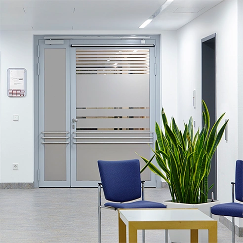 Frosted window film on a glass door and window inside a waiting room of what could be a medical center