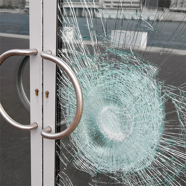 A safety film prevented entry into a glass door by firmly holding the broken glass shards together.