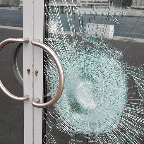 A safety film prevented entry into a glass door by firmly holding the broken glass shards together.
